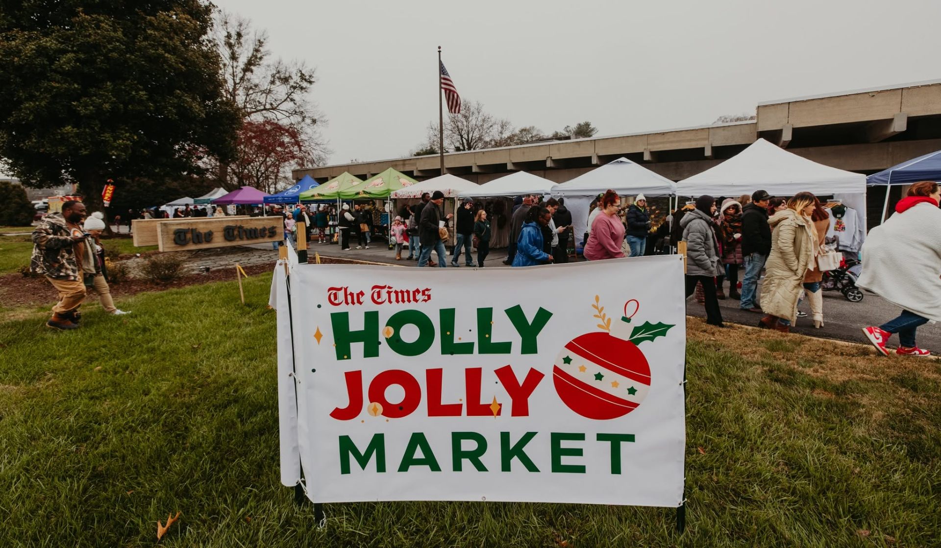 Holly Jolly Market banner with vendor tents at The Times