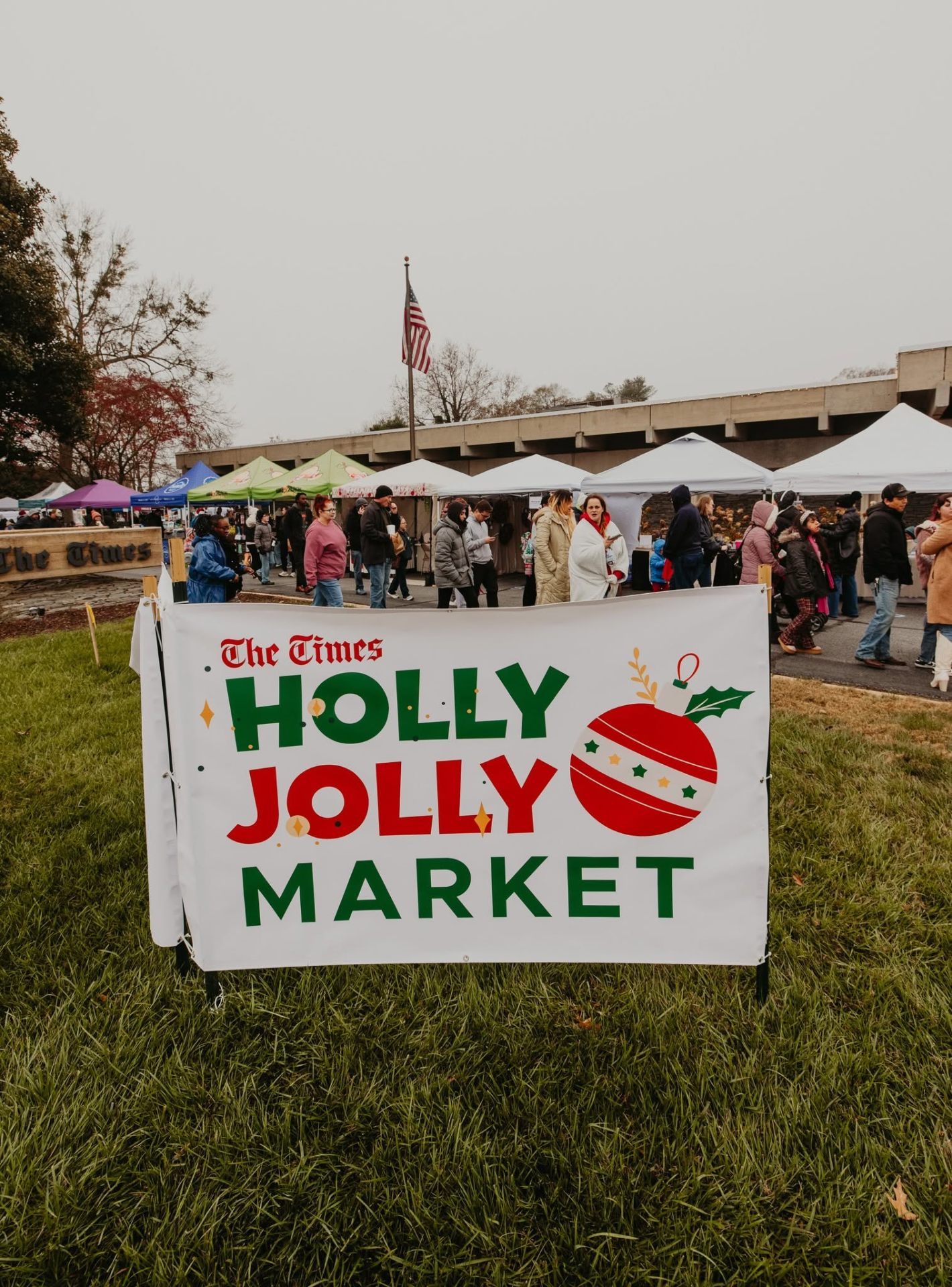 Crowd browsing vendor tents at the Holly Jolly Market